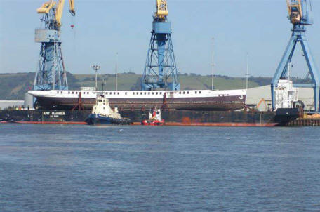 Nomadic on a floating barge arriving back to Harland and Wolff in 2006